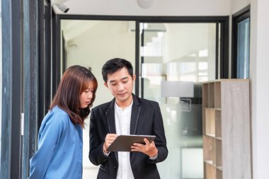 Bir iş ekibinin bir proje geliştirmesi için tablet üzerinde çalışıyorlar, düşünüyorlar ve planlıyorlar. Teknoloji pazarlama grubu web araştırmalarıyla çalışıyor. Ofis çalışanları tabletlere birlikte bakıyor..