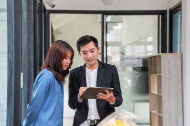 Bir iş ekibinin bir proje geliştirmesi için tablet üzerinde çalışıyorlar, düşünüyorlar ve planlıyorlar. Teknoloji pazarlama grubu web araştırmalarıyla çalışıyor. Ofis çalışanları tabletlere birlikte bakıyor..