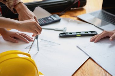 İş sahasında modeller ve planlar oluşturmak için ortaklar ve mühendislik araçlarıyla çalışan mühendisler için mühendisler veya mimarlarla görüşmeyi kabul et. İnşaat konsepti Mühendis kavramı.