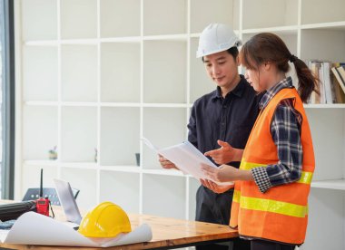 İş sahasında modeller ve planlar oluşturmak için ortaklar ve mühendislik araçlarıyla çalışan mühendisler için mühendisler veya mimarlarla görüşmeyi kabul et. İnşaat konsepti Mühendis kavramı.