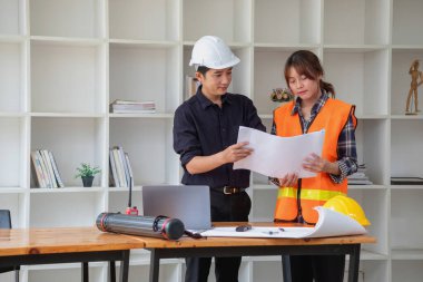 İş sahasında modeller ve planlar oluşturmak için ortaklar ve mühendislik araçlarıyla çalışan mühendisler için mühendisler veya mimarlarla görüşmeyi kabul et. İnşaat konsepti Mühendis kavramı.