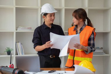 İş sahasında modeller ve planlar oluşturmak için ortaklar ve mühendislik araçlarıyla çalışan mühendisler için mühendisler veya mimarlarla görüşmeyi kabul et. İnşaat konsepti Mühendis kavramı.