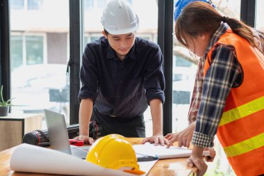 İş sahasında modeller ve planlar oluşturmak için ortaklar ve mühendislik araçlarıyla çalışan mühendisler için mühendisler veya mimarlarla görüşmeyi kabul et. İnşaat konsepti Mühendis kavramı.