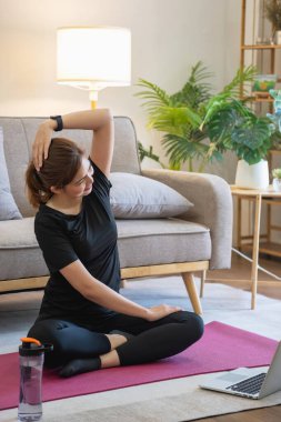 Kadınlar esneme hareketleri yapıyor, evde spor yapıyorlar. Kadınlar sağlık ve sağlık için yatak odalarında yoga yapıyorlar. Sağlıklı, sakin bir kadın olarak ya da ev zemininde çalışıyor..