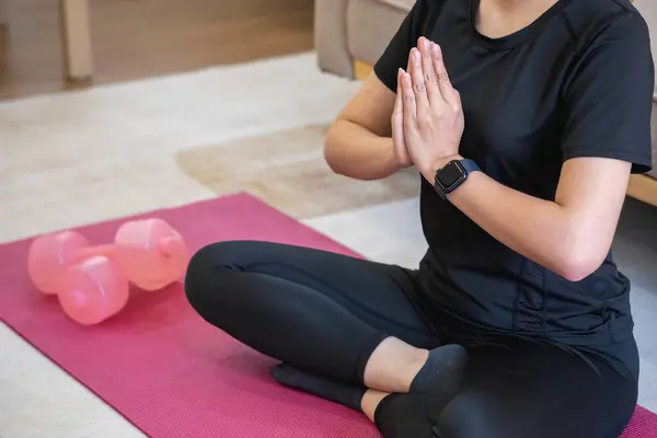 Healthy young woman doing breathing exercises at home, beautiful woman meditating at home with eyes closed, practicing yoga, doing pranayama techniques Mindfulness meditation concep