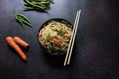 Wok udon eriştesini bir kaseye attı. Yukarıdan görüntüle.