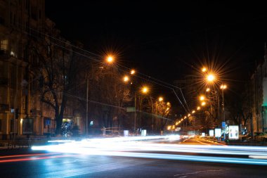 Geceleri şehrin caddelerinde trafik ışıkları yanar. Uzun pozlu çekim. Geceleri sokaklar