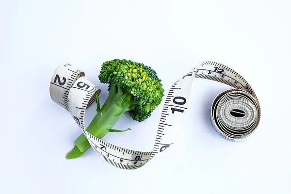 Fresh broccoli isolated on white background whith measuring tape. Healthy lifestyle concept. Diet concept. Weight loss concept.