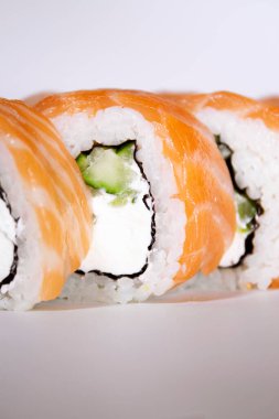 Salatalıklı somon suşi rulosu ve beyaz kutuda Philadelphia.