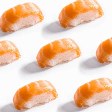 Beyaz arka planda birçok somon nigiri