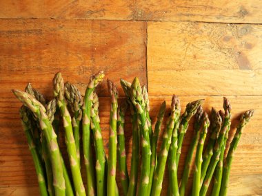 Mutfaktaki ahşap masada olgun kuşkonmaz manzarası.