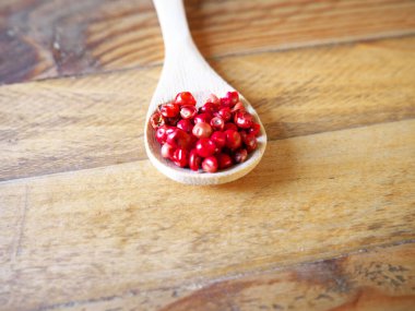 Tahta kaşıkta pembe biberler. Yukarıdan görüntüle