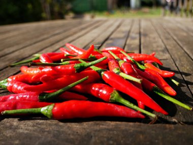 Ahşap bir masada kırmızı biberlerin yakın plan çekimi.