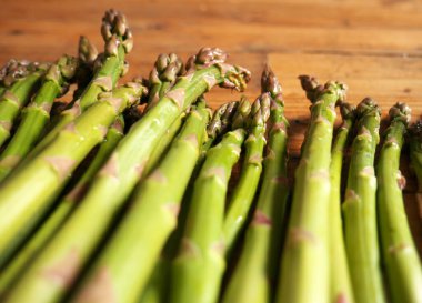 Mutfaktaki ahşap masada olgun kuşkonmazın yakın çekimi.