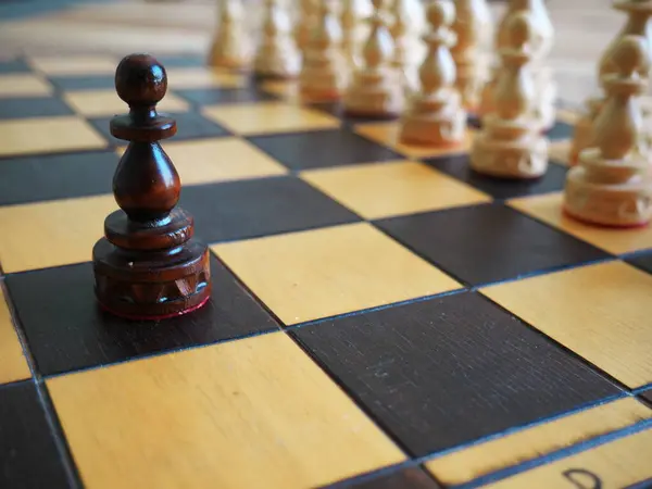 stock image Photo of a close-up of a black chess pawn facing the opponent's pieces