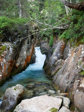 Fransa 'nın güneybatısındaki Pireneler Ulusal Parkı' nda güneşli bir günde çekilmiş bir şelale fotoğrafı.