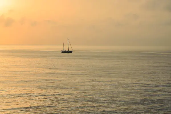 Denizde büyülü bir gün batımı, yalnız bir tekne. Yüksek kalite fotoğraf