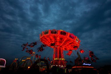 Mekanik oyun, Ekim Festivali 'nde uçan sandalyeler. Almanya' nın Münih şehrinde gece vakti.