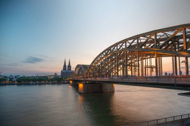 Almanya 'da günbatımında arka planda Hohenzollern Köprüsü ve Köln Katedrali