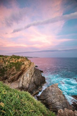 Punta Cometa bakış açısı Oaxaca, Meksika 'da güzel pembe bir günbatımında