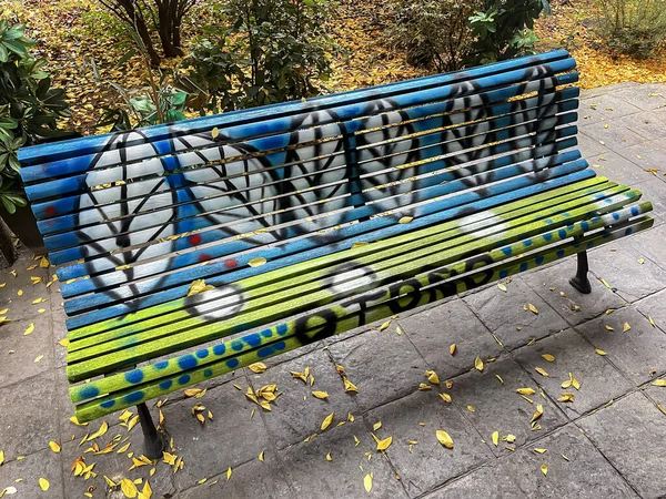 Park Bench Painted Yellow Blue Leaf Message Spanish Meaning Autumn — Stock Photo, Image
