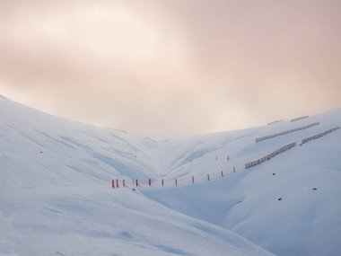 a snowy landscape of ski slopes with a sunset sky, Ampriu mountain pass, Cerler, Huesca, Aragonese Pyrenees, Spain