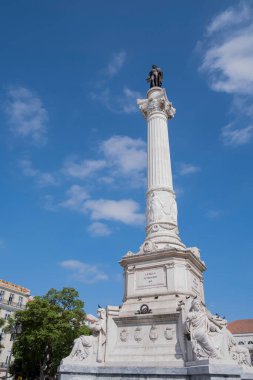 A huge white stone column with a bronze statue of a king of Portugal Pedro IV at the top, Rossio Square, Lisbon, Portugal, vertical
