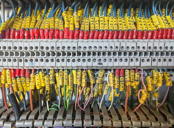 interior of an electrical cabinet with a terminal block full of numbered wires, industrial automation, wiring diagrams of machine connections , horizontal