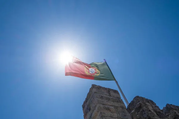 在阳光明媚的日子里 在里斯本圣乔治城堡的城垛上飘扬着葡萄牙的国旗 水平的 — 图库照片