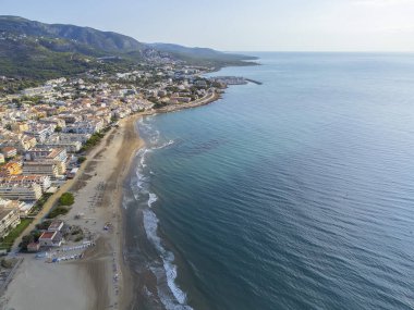 Arka planda Sierra de Irta Doğal Parkı olan El Cargador plajının hava görüntüsü, İHA manzaralı, yatay