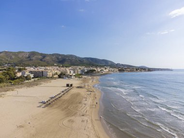 Arkasında Sierra de Irta Doğal Parkı olan Alcober 'deki El Cargador plajının insansız hava aracı görüntüsü.