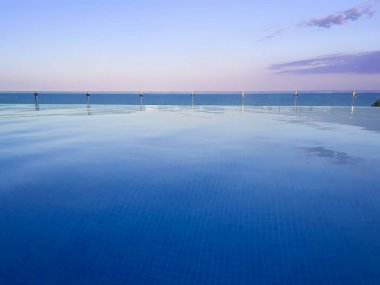 Sonsuzluk havuzu, gün batımında denize bakan leylak rengi gökyüzü, ilk insan manzarası, kopyalama alanı, yatay.