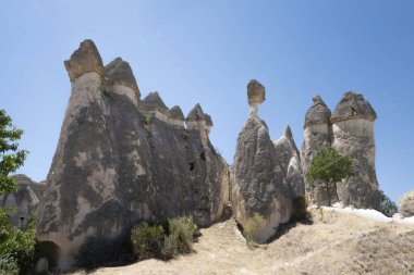Goreme 'de aşınmış kayaların tipik jeolojik oluşumu, bir oluşumun tepesinde hassas bir dengede büyük bir kaya, peri bacası, Kapadokya, Türkiye' de, yatay