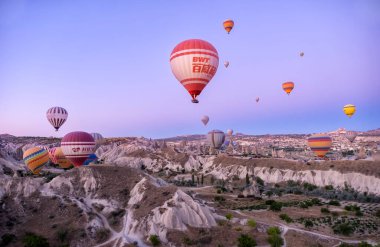 Sıcak hava balonları peri bacalarının üzerinde uçuyor, şafak vakti Goreme havaalanında, Kapadokya, Kızıl Vadi, Türkiye, Goreme Milli Parkı