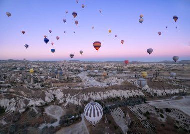 Peri bacaları üzerinde uçan sayısız sıcak hava balonu, şafak vakti Goreme havaalanında, Kapadokya, Türkiye, yatay