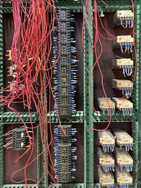 an old machine electrical cabinet with old electrical components, contacts with red cut wires and red cut wires, vintage technology, vertical