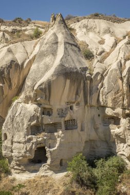 Peri bacalarına oyulmuş tipik taş evler volkanik kayalara güvercinler oyulmuş, Goreme 'de kaya büyüsü, Kapadokya, Türkiye, dikey