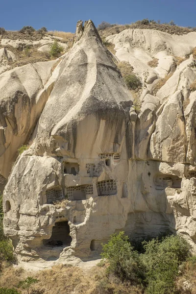 Peri bacalarına oyulmuş tipik taş evler volkanik kayalara güvercinler oyulmuş, Goreme 'de kaya büyüsü, Kapadokya, Türkiye, dikey