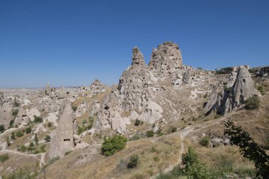 Kapadokya 'daki Uchisar mağarasının genel manzarası volkanik kayalardan oyulmuş kalesi mavi gökyüzüne karşı, yatay