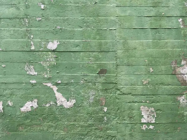 green painted concrete block wall with paint flaws and chipping, cement wall in bad condition, wall texture, horizontal