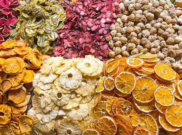 close up of a store display of dehydrated fruits, oranges, kiwis, apples, strawberries, pineapple slices and dehydrated figs