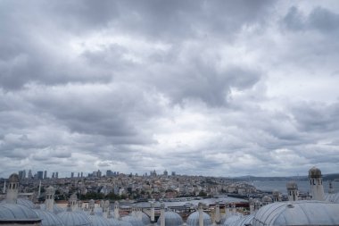 panoramic view of the city of Istanbul from the viewpoint of the Suleiman Mosque, with its typical roofs in the foreground, on a cloudy day with stormy atmosphere, copy space clipart