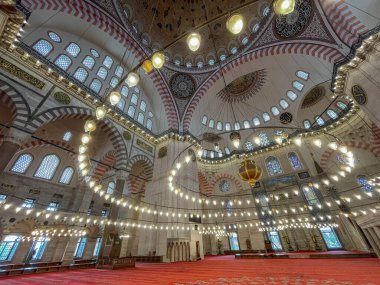 Süleyman Camii 'nin görkemli avizesi, tavanı ve kırmızı halısıyla geniş açılı manzarası var. Halk yok, Müslüman dini, İstanbul Türkiye, yatay.