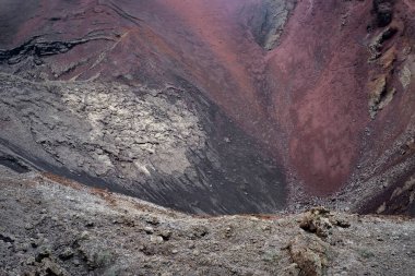 Bir volkanın krateri, volkanik kaya ve lav dokusu, doğal soyutlama, arka plan, koyu gri ve kırmızı lav kaya oluşumları, soğutulmuş lav ve kül karışımı, yatay volkanik manzara
