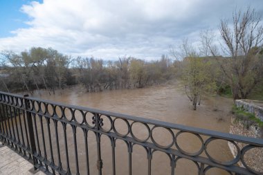 Henares nehri Guadalajara 'dan geçerek Arap köprüsünün altından geçiyor. Şiddetli yağmurların ardından sel baskınları, ön planda taşma tehlikesi, tırabzan tehlikesi var.