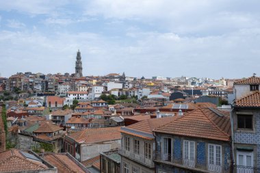 Porto, Portekiz 'in panoramik manzarası, kırmızı çatıları ve Clerigos Kulesi tarihi şehrin üzerinde yükselen parlak mavi gökyüzü, yatay