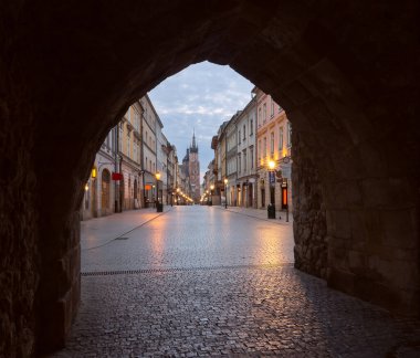 Facades of old houses on the central street of the city at dawn. Krakow. Poland.