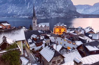 Eski şehrin resimli manzarası, dağların arka planına ve gün batımında bir göle karşı. Hallstatt. Avusturya.