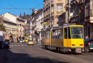 Güzel geleneksel evler ve güneşli bir günde eski sarı bir tramvay. Lvov. Ukrayna.