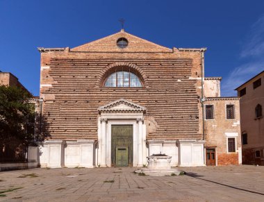 Geleneksel bir Katolik kilisesi ve kuyusu olan küçük bir kasaba meydanı. Venedik. İtalya.